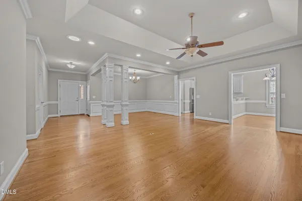 a view of empty room with wooden floor and ceiling fan