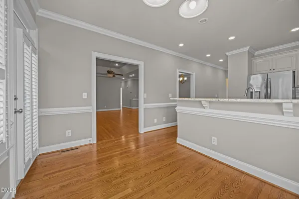 a view of a hallway to kitchen and wooden floor