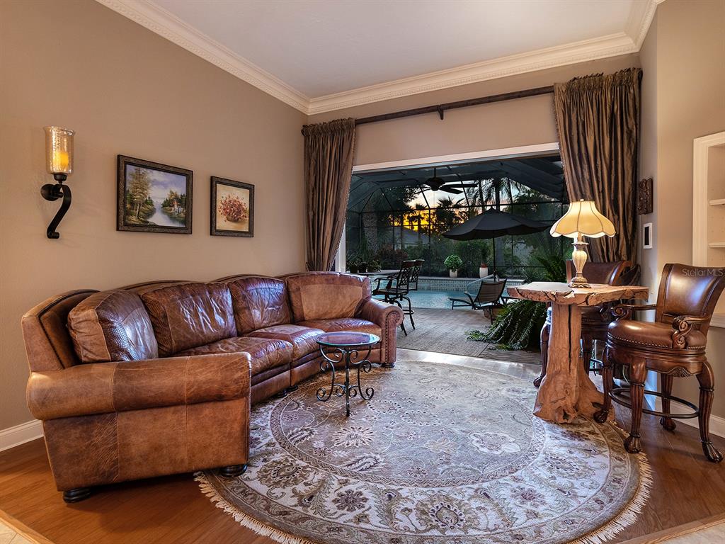 10528 Cheval Place Lakewood Ranch, FL 34202 - Photo 13 of 71 a living room with furniture a fireplace and a flat screen tv