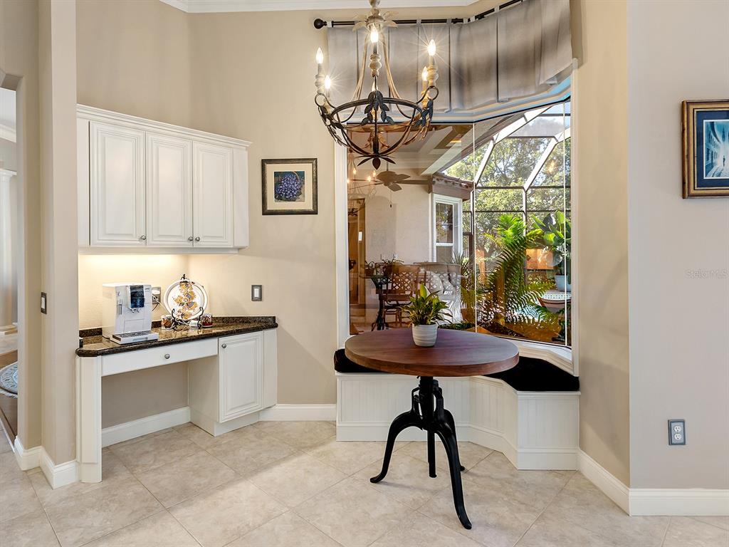 10528 Cheval Place Lakewood Ranch, FL 34202 - Photo 24 of 71 a kitchen with stainless steel appliances granite countertop sink table and chairs