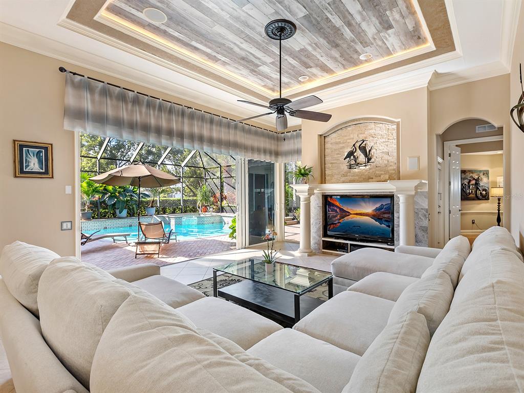 10528 Cheval Place Lakewood Ranch, FL 34202 - Photo 27 of 71 a living room with furniture a fireplace and a chandelier