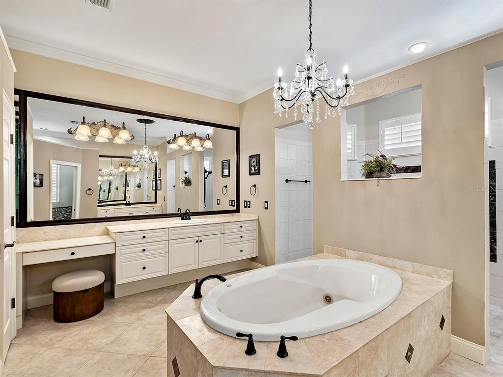 10528 Cheval Place Lakewood Ranch, FL 34202 - Photo 36 of 71 a spacious bathroom with a granite countertop sink a large mirror and a bathtub