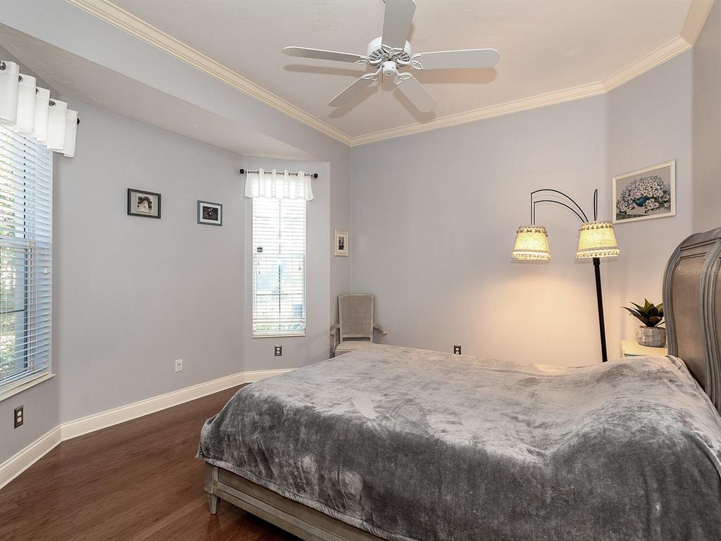 10528 Cheval Place Lakewood Ranch, FL 34202 - Photo 38 of 71 a bedroom with a bed and wooden floor