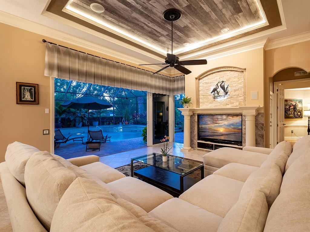 10528 Cheval Place Lakewood Ranch, FL 34202 - Photo 49 of 71 a living room with furniture a flat screen tv and a fireplace