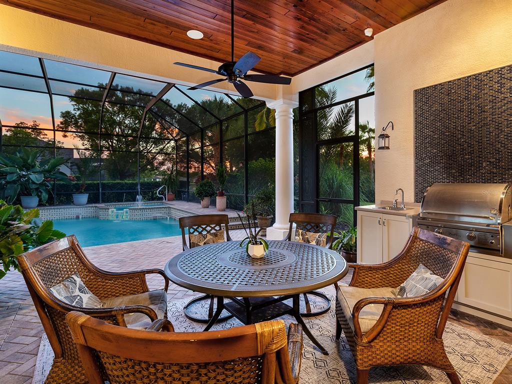 10528 Cheval Place Lakewood Ranch, FL 34202 - Photo 56 of 71 a patio with a table and chairs and a barbeque