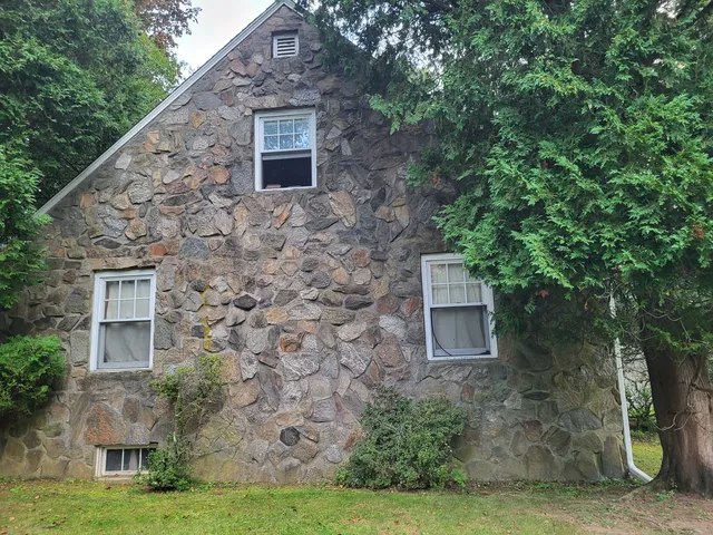 a brick building with a yard and large trees