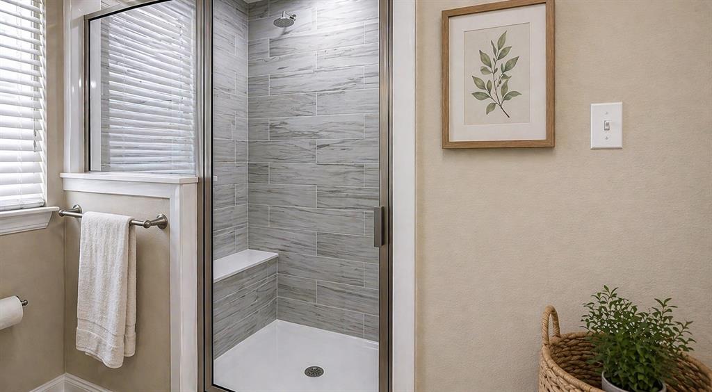 212 East Walker Street Denison, TX 75021 - Photo 6 of 12 Glass-enclosed shower featuring large format tile surround and a built-in bench.