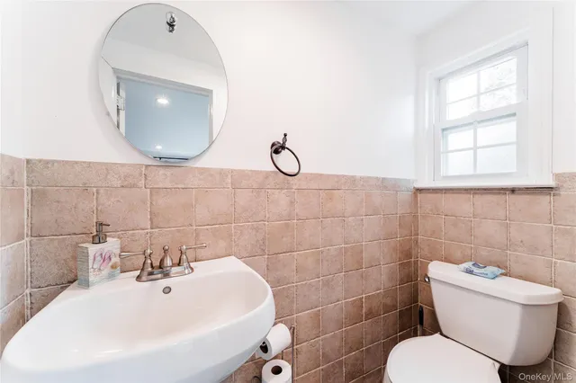 a bathroom with a toilet sink and mirror