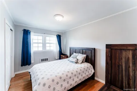 a bedroom with a large bed and wooden floor
