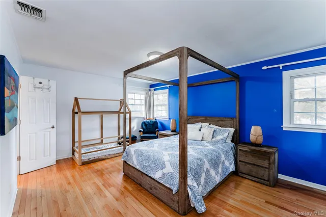 a bedroom with a bed wooden floor and window