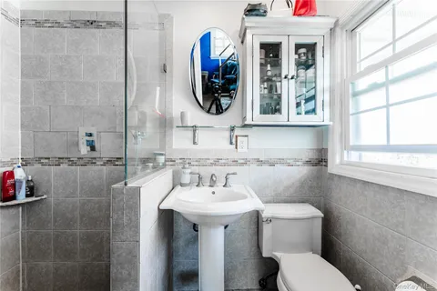 a bathroom with a toilet sink and mirror