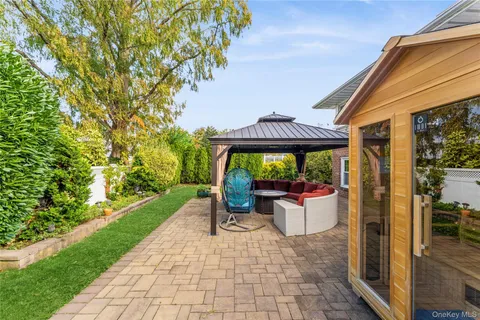 a view of a patio with table and chairs potted plants with wooden floor and fence