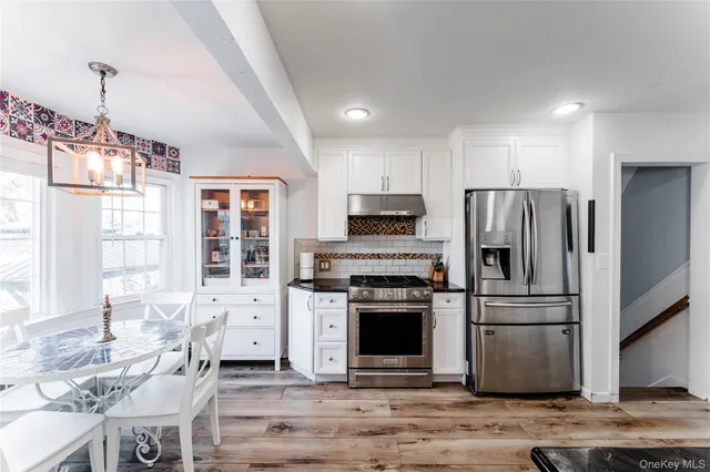 a kitchen with stainless steel appliances granite countertop a refrigerator stove top oven and sink