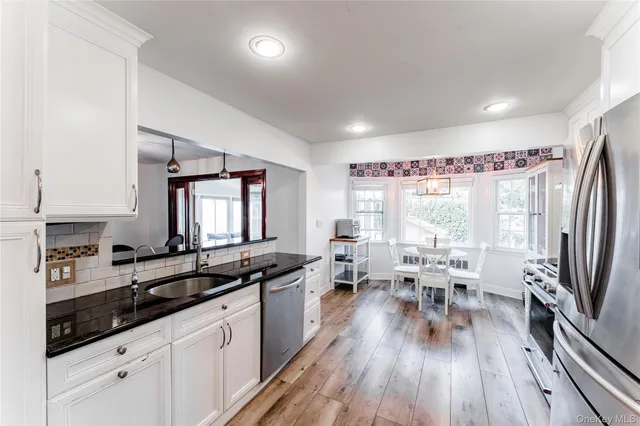 a large kitchen with a large window and stainless steel appliances