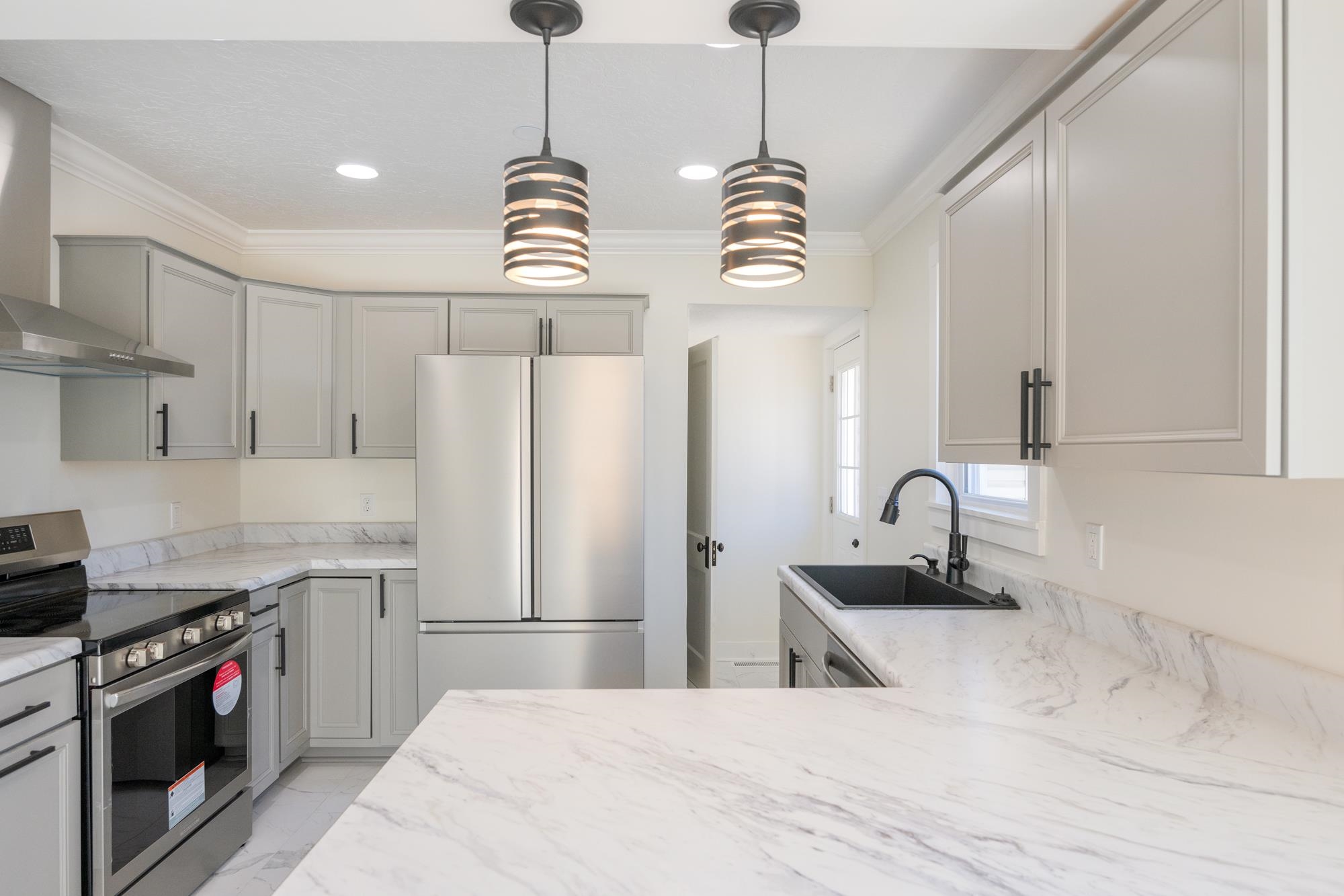 242 Broad Street North Lexington, TN 38351 - Photo 4 of 40 Kitchen featuring stainless steel electric stove, gray cabinetry, fridge, wall chimney exhaust hood, and crown molding
