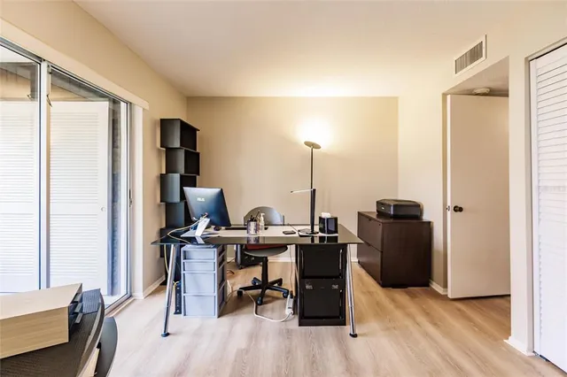 a view of a workspace with furniture and a window