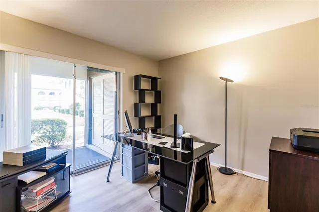 a view of a workspace with furniture and a window