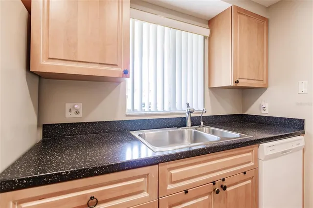 a kitchen with granite countertop a sink and a white cabinets