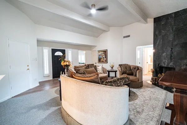 a living room with furniture a fireplace and gym equipment