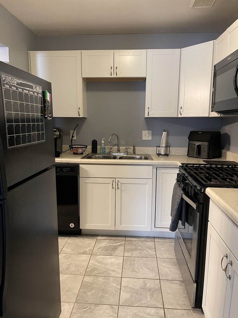 9-s116 S Frontage Road, Unit 27104 Darien, IL 60527 - Photo 3 of 15 a kitchen with a sink a stove and cabinets