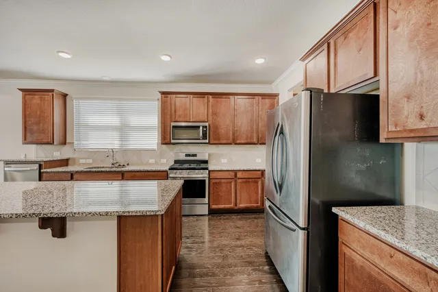 a kitchen with stainless steel appliances granite countertop a sink stove and refrigerator