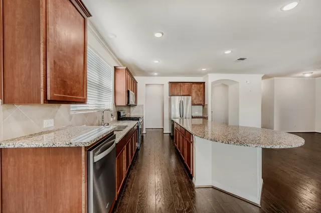 a kitchen with stainless steel appliances granite countertop a stove a sink and a refrigerator