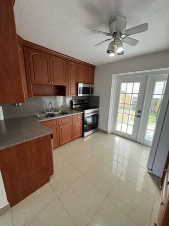 a kitchen with stainless steel appliances granite countertop a stove top oven a sink a counter space and cabinets