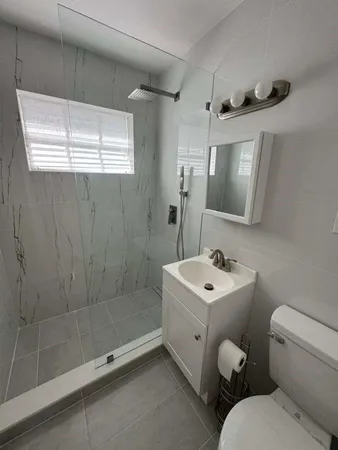a bathroom with a sink toilet a mirror and shower