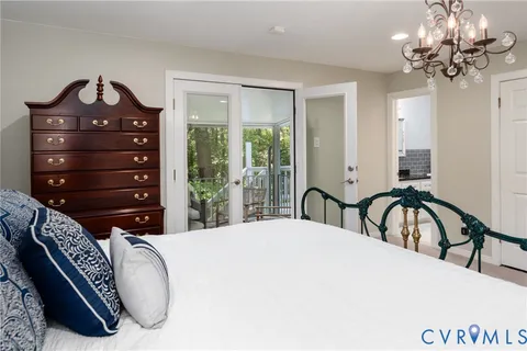 a bedroom with a bed a chandelier and a dresser