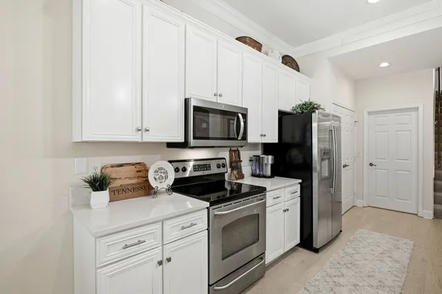 a kitchen with white cabinets and stainless steel appliances