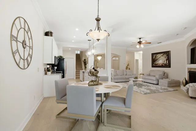 a dining room with wooden floor a chandelier a wooden table and chairs