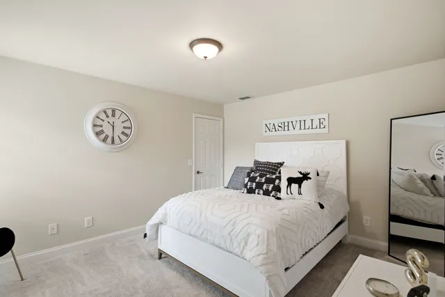a bedroom with a bed and a lamp with the wooden floor
