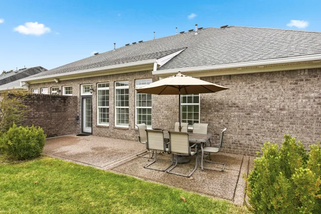 a backyard of a house with table and chairs