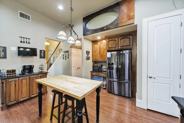 a kitchen with stainless steel appliances a refrigerator a stove a sink dishwasher and a refrigerator with wooden floor