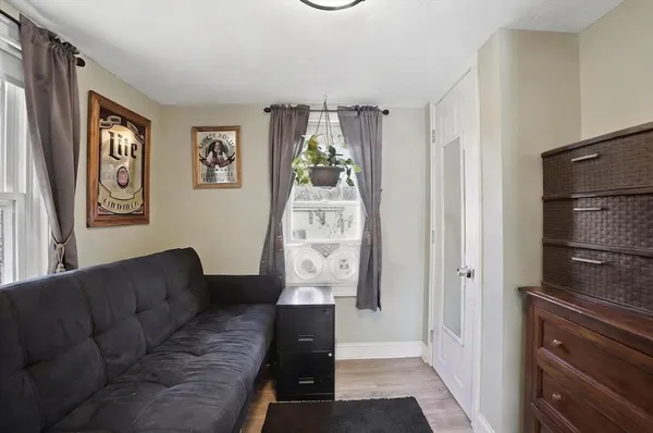 a living room with stainless steel appliances furniture and a window