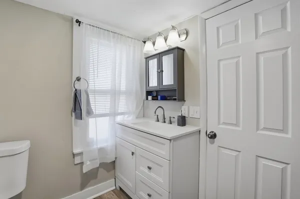 a bathroom with a sink a toilet and a mirror