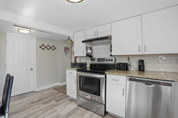 a kitchen with stainless steel appliances granite countertop a stove a sink and a refrigerator