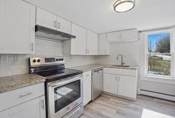 a kitchen with granite countertop cabinets stainless steel appliances and wooden floor