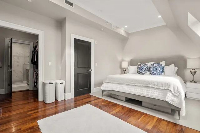 a bedroom with a bed and wooden floor