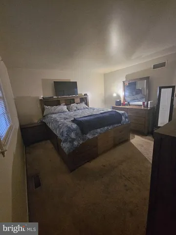 a view of a bedroom with bed and window