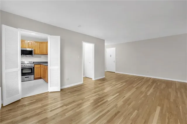 a view of a kitchen with wooden floor and a refrigerator