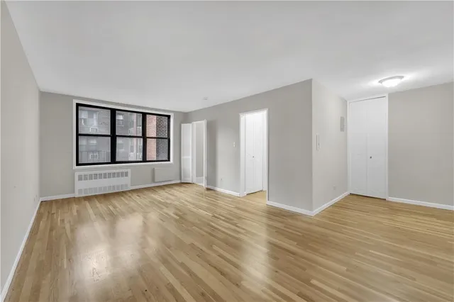 a view of an empty room with a window and fireplace