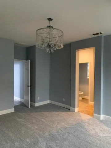 a view of a hallway with a chandelier fan