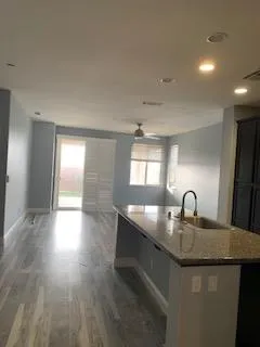 a kitchen with granite countertop a sink and cabinets