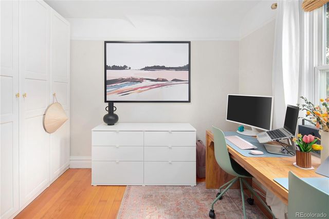 a view of a brick house with a small yard and a wooden fence