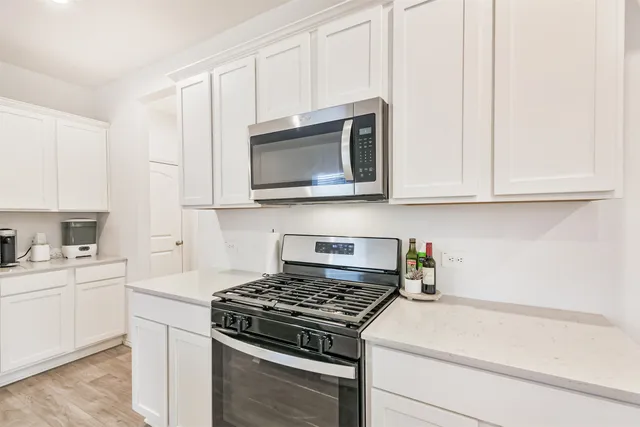 a kitchen with stainless steel appliances granite countertop white cabinets sink and dishwasher
