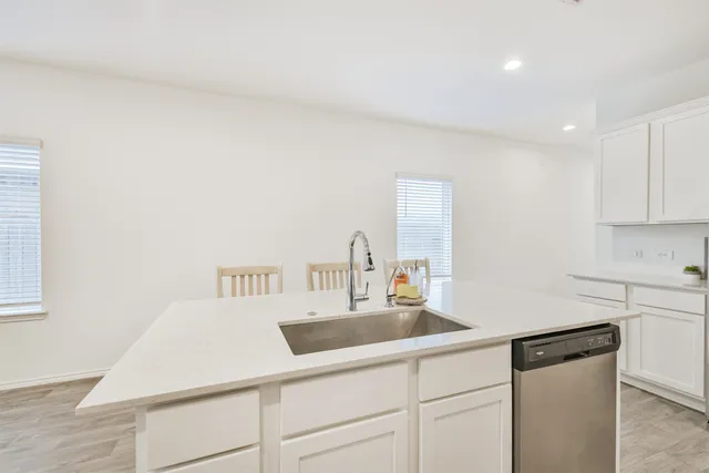 a kitchen with a sink dishwasher and cabinets