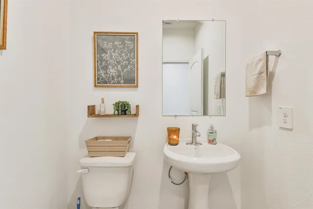 a bathroom with a sink a toilet and mirror