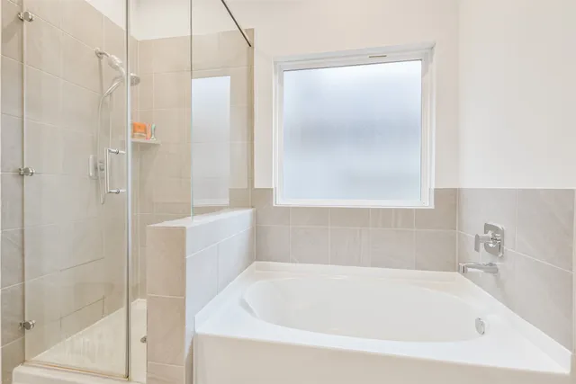 a white bath tub sitting next to a white sink and vanity