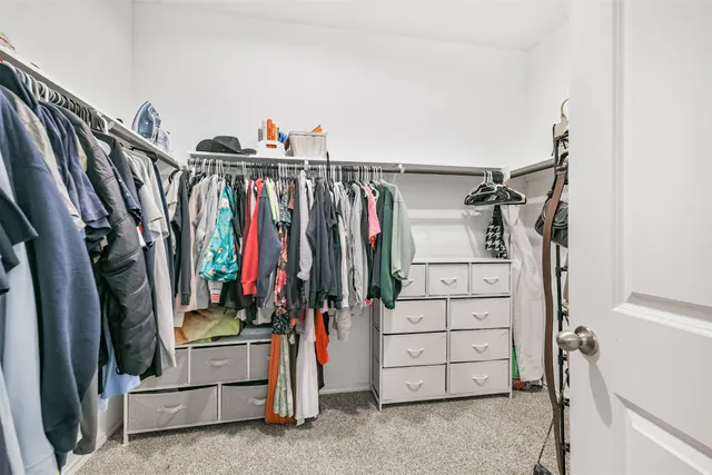 a view of walk in closet with clothes